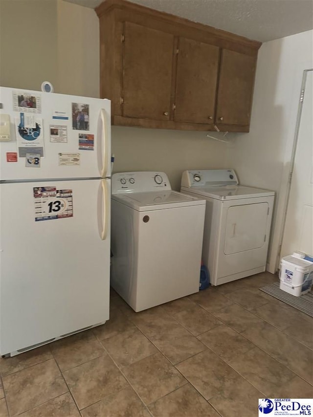 clothes washing area with washing machine and dryer and light tile patterned floors