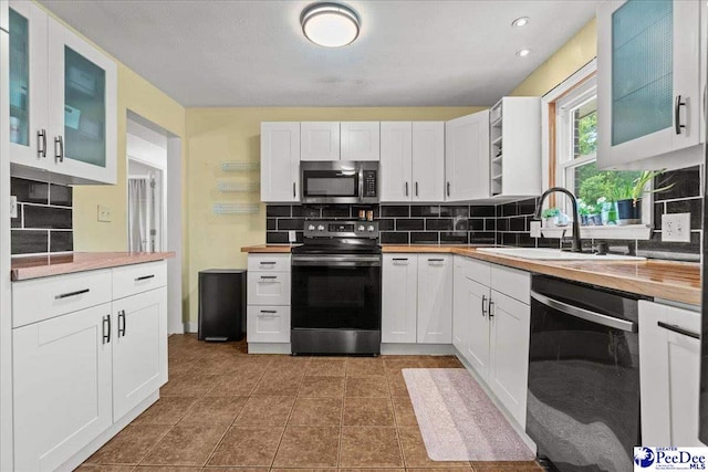 2217 W Mccown Dr, Florence, SC 29501 - kitchen featuring appliances with stainless steel finishes, backsplash, white cabinetry, a sink, and glass insert cabinets