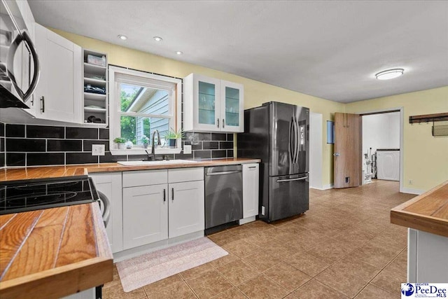 2217 W Mccown Dr, Florence, SC 29501 - kitchen with stainless steel appliances, a sink, backsplash, white cabinets, and glass insert cabinets