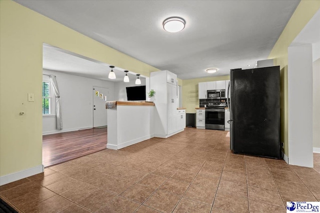 2217 W Mccown Dr, Florence, SC 29501 - kitchen with stainless steel appliances, white cabinets, baseboards, tile patterned floors, and open floor plan