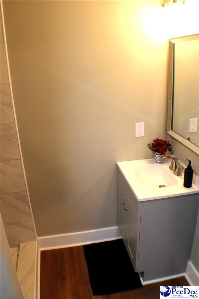 bathroom featuring baseboards, wood finished floors, and vanity