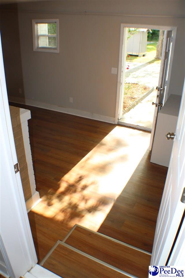 stairway featuring baseboards, plenty of natural light, and wood finished floors