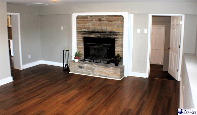 unfurnished living room with baseboards, wood finished floors, and a fireplace
