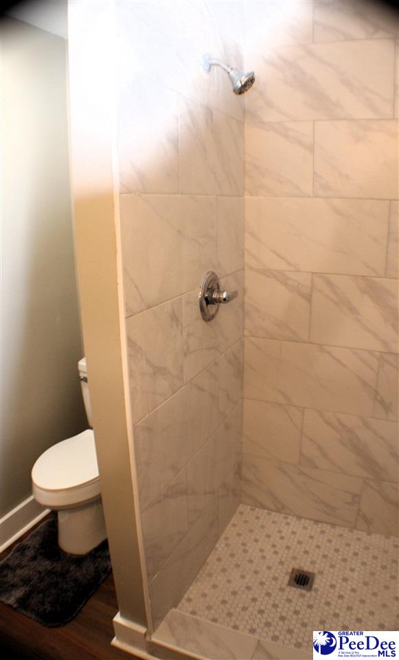 full bath featuring a shower stall and toilet