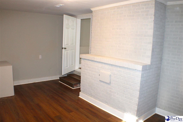 spare room with baseboards, crown molding, and wood finished floors