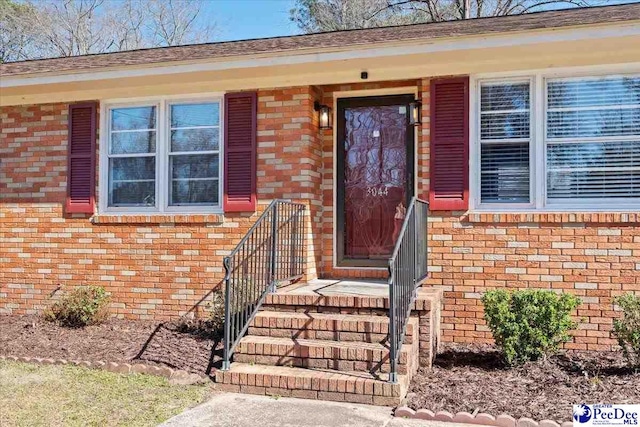 property entrance featuring brick siding