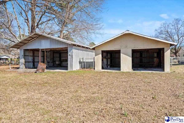 view of pole building with fence and a lawn