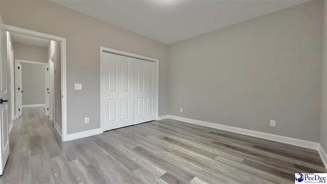 unfurnished bedroom featuring light hardwood / wood-style floors and a closet