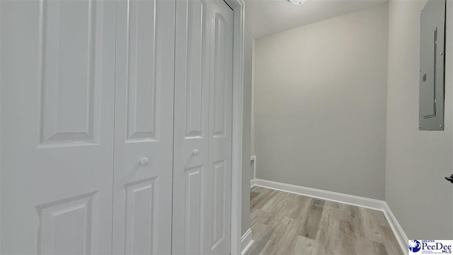 hall featuring electric panel and light hardwood / wood-style flooring