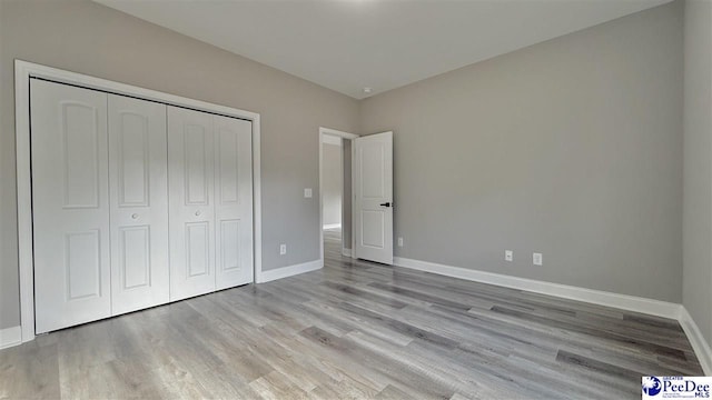 unfurnished bedroom featuring light wood-type flooring and a closet