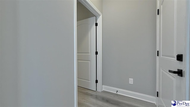 hallway with light hardwood / wood-style floors