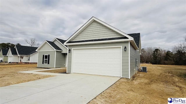 view of front of home with a garage and central AC