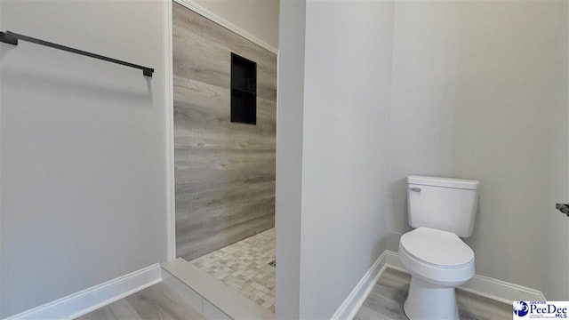 bathroom with walk in shower, hardwood / wood-style floors, and toilet