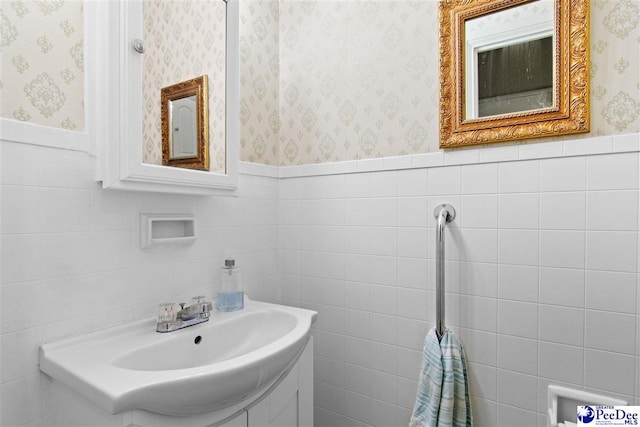 bathroom featuring vanity and tile walls