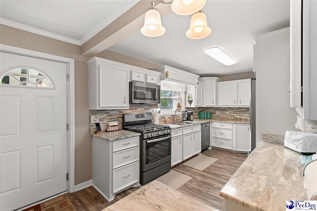 kitchen featuring white cabinetry, hanging light fixtures, ornamental molding, and appliances with stainless steel finishes