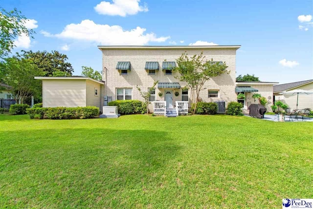 rear view of house featuring central AC and a lawn