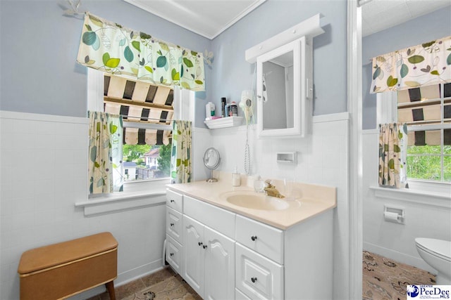 bathroom featuring tile walls, vanity, and toilet