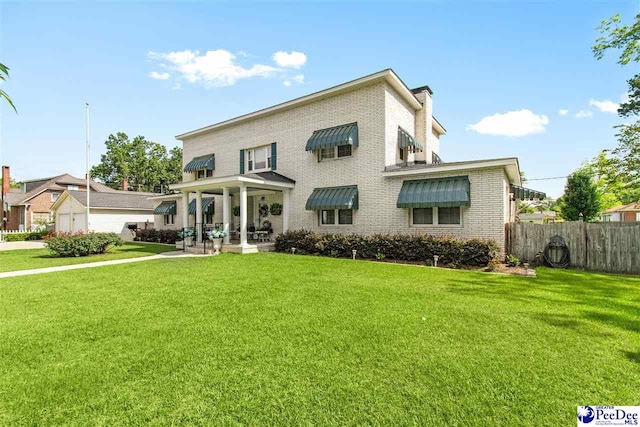 rear view of house featuring a yard and a patio area