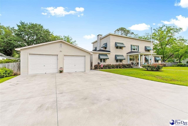 view of front of home featuring a garage, covered porch, and a front lawn