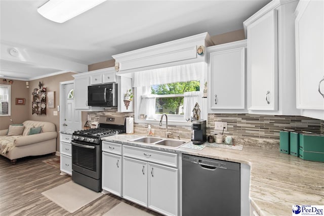 kitchen featuring sink, gas range, tasteful backsplash, dishwasher, and white cabinets