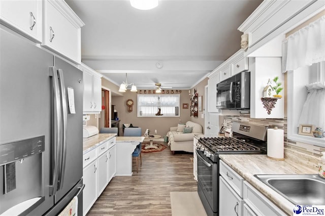 kitchen featuring white cabinetry, wood-type flooring, hanging light fixtures, stainless steel appliances, and backsplash