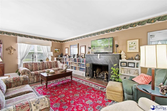 living room featuring a premium fireplace, hardwood / wood-style floors, and crown molding