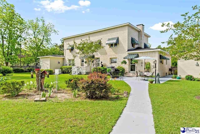 back of house with a yard and a patio