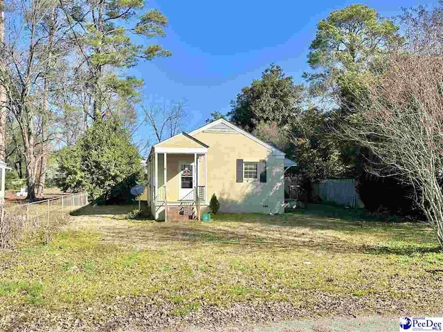 view of front of property featuring entry steps, fence, and a front lawn