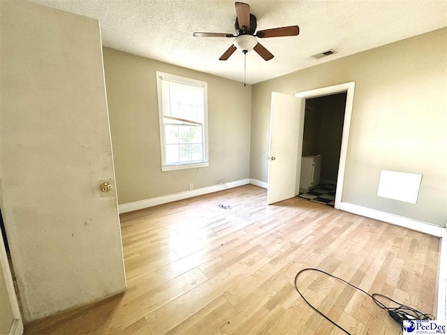 unfurnished bedroom with light wood-type flooring, visible vents, a textured ceiling, and baseboards