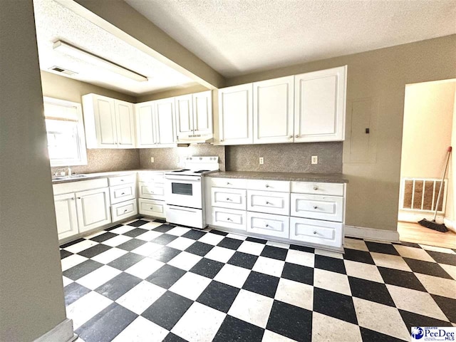 kitchen featuring dark floors, under cabinet range hood, visible vents, white cabinets, and white range with electric stovetop