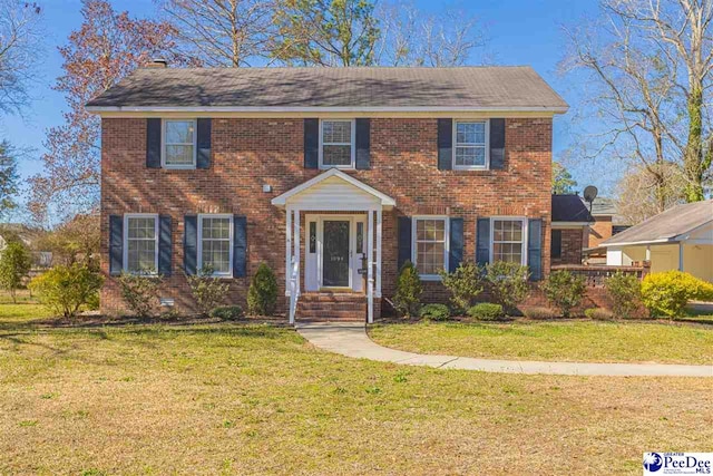 colonial home featuring brick siding and a front yard