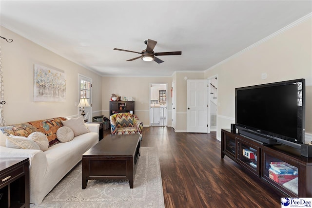 living area with a ceiling fan, crown molding, baseboards, and wood finished floors