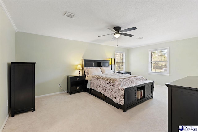 bedroom featuring light carpet, baseboards, visible vents, and a textured ceiling