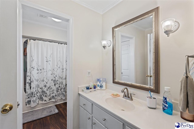 bathroom featuring visible vents, wood finished floors, vanity, and crown molding