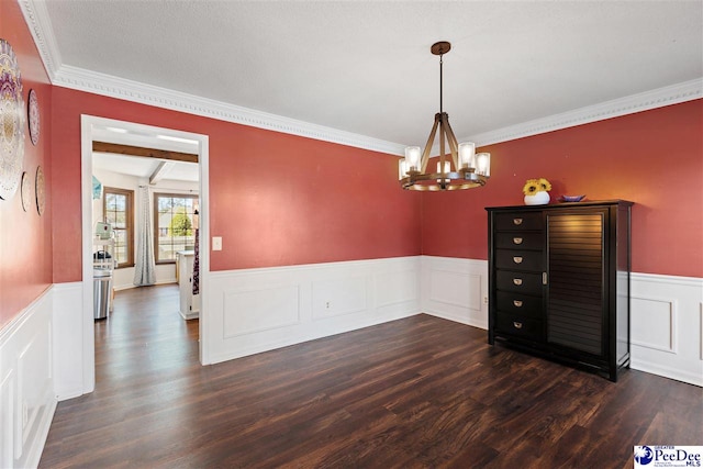 unfurnished dining area featuring dark wood-style floors, a wainscoted wall, and a notable chandelier