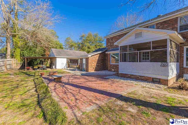 view of front of property with a sunroom, fence, and brick siding