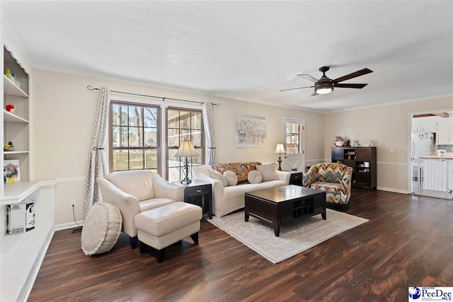 living room featuring baseboards, dark wood-type flooring, plenty of natural light, and crown molding