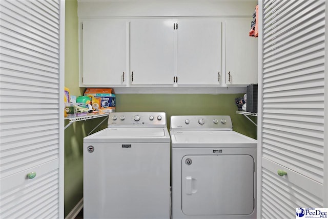 laundry area featuring washer and clothes dryer and cabinet space