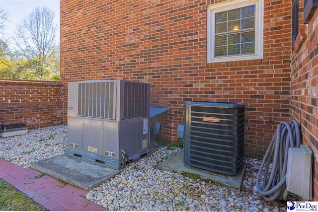 details featuring central AC and brick siding