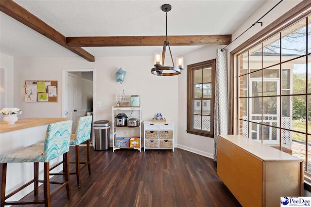 dining room featuring a chandelier, beam ceiling, dark wood finished floors, and baseboards