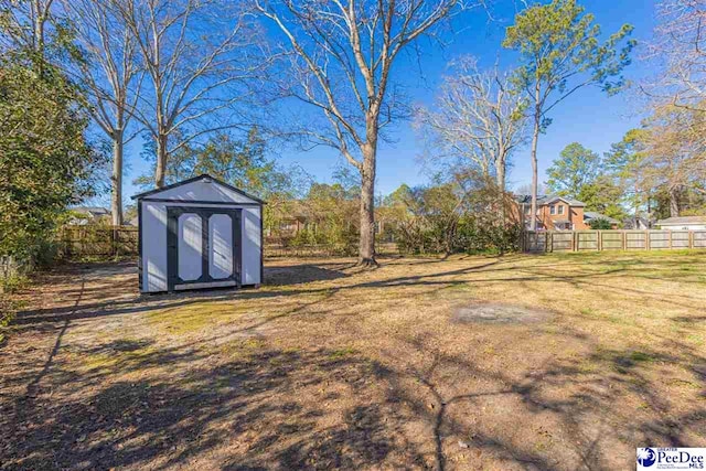 view of yard with a storage unit, an outdoor structure, and fence