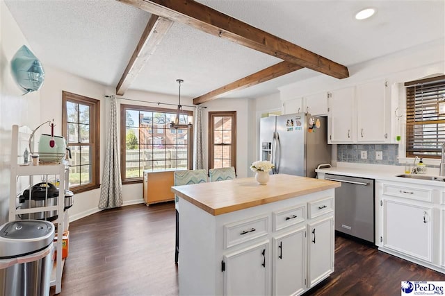 kitchen featuring tasteful backsplash, dark wood-style floors, appliances with stainless steel finishes, white cabinetry, and a sink