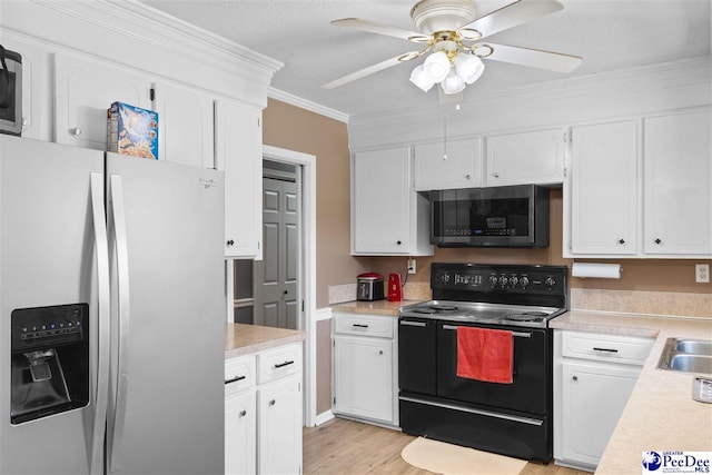 kitchen featuring light wood-style flooring, white cabinetry, light countertops, appliances with stainless steel finishes, and crown molding