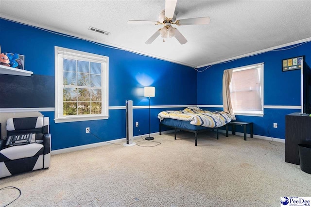 bedroom featuring carpet floors, visible vents, a textured ceiling, and multiple windows