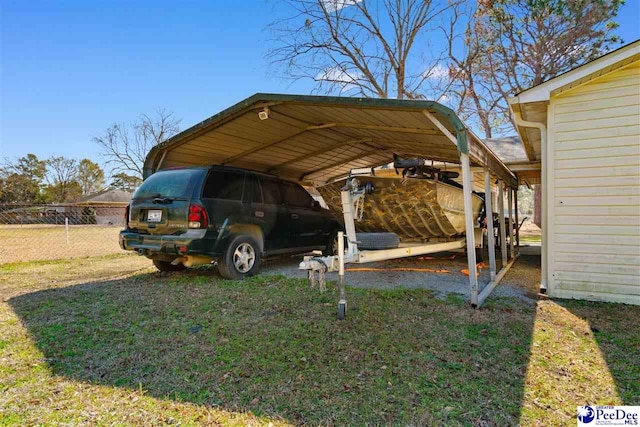 view of vehicle parking with a carport and fence