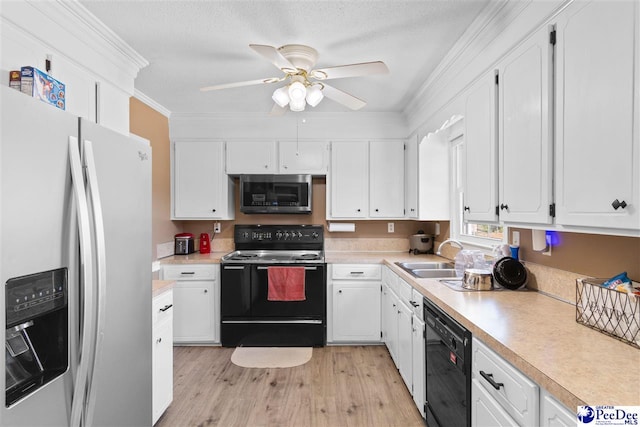 kitchen featuring a sink, light wood-style floors, light countertops, black appliances, and crown molding