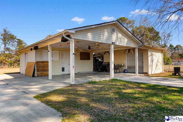 view of front facade with a carport, concrete driveway, and fence