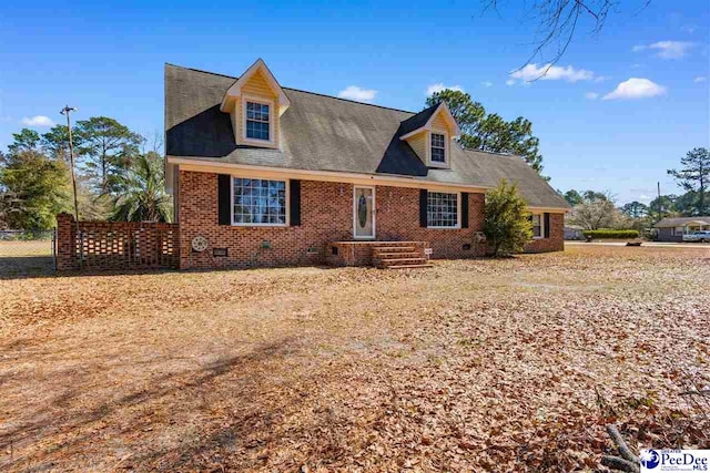 cape cod house with crawl space, fence, and brick siding