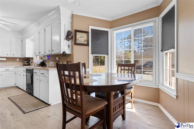 dining room with plenty of natural light, a ceiling fan, and light wood-style floors