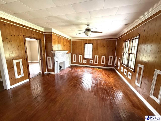 251 Papermill Rd, Florence, SC 29506 - unfurnished living room featuring a ceiling fan, dark wood-style floors, wooden walls, crown molding, and a brick fireplace